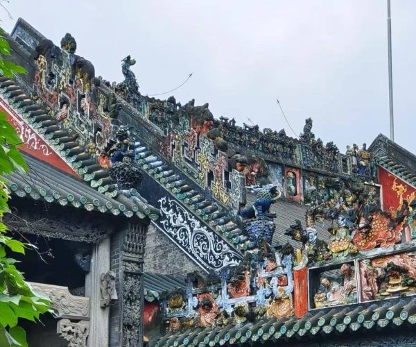 Chen Clan Ancestral Hall,Guangzhou,Chinatour Ornate Chinese temple roof with colorful ceramic figures, dragons, and decorative tiles along the ridge.