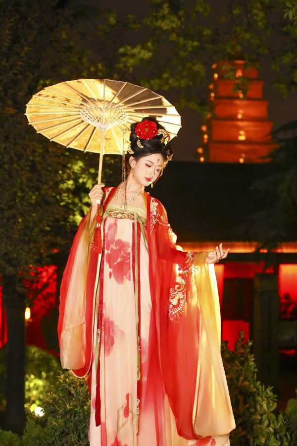 Hanfu photoshoot, xingqing palace, xi'an, solo, tang dynasty, female, chinatravel, Woman in a red and pink traditional Chinese hanfu, holding a paper parasol, posing gracefully at night with illuminated lanterns in the background.