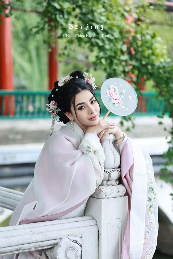 Hanfu Photoshoot, Beijing, Zhongshan park, female, chinatravel, Woman in pale pink traditional Hanfu with floral hairpieces, posing beside a carved railing and a floral fan outdoors.