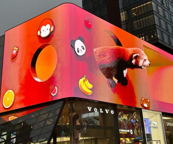 Huge digital billboard above a Volvo store with a bright red–orange background, featuring panda icons, fruit graphics, and a red panda emerging from a curved shape.