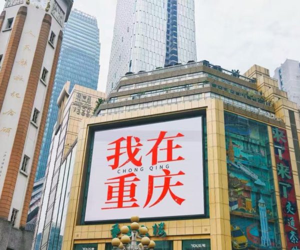 Jiefangbei Pedestrian Street,Chongqing,Chinatour Large billboard on a gold-framed building in Chongqing displaying red Chinese text '我在重庆' (I'm in Chongqing).