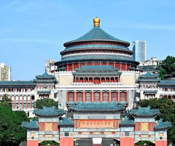 People’s Assembly Hall,Chongqing,Chinatour Large Chinese temple complex with a circular, multi-tiered roofed hall and ornate gate in the foreground, flanked by red columns and turquoise tiles against a city skyline.