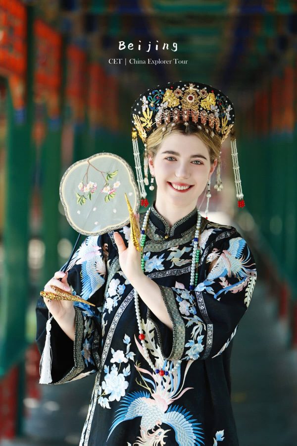 hanfu photoshoot, zhongshan park, beijing, female, solo, chinatrip, Smiling woman in an ornate traditional Chinese headdress and robe, holding a round embroidered fan.