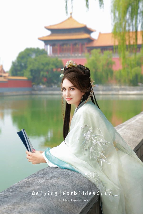 hanfu photoshoot, the forbidden city, beijing, female, solo, chinatravel, Woman in elegant hanfu by a stone railing with a lake and traditional Chinese tower in the background; Beijing travel scene (Forbidden City/CET China Explorer Tour).