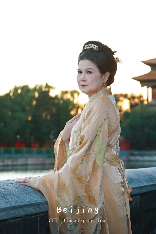 Hanfu Photoshoot, Beijing, forbidden city exterior, female, chinatravel, Woman in a gold traditional Chinese dress stands by a stone railing with a historic Chinese building in the background; travel photo for Beijing/CET China Explorer Tour.