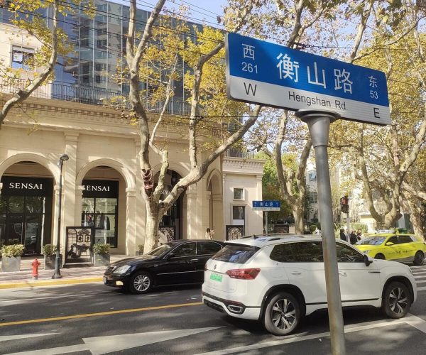 Hengshan Road, Shanghai, chinatrip, Street scene with a blue Hengshan Road street sign in Chinese and English, atop a pole, above a crosswalk and parked cars.