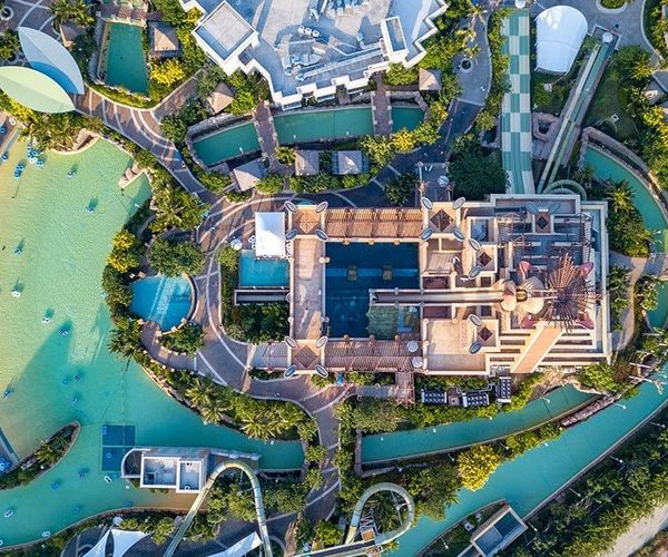 Atlantis Waterpark,Sanya,Chinatravel Aerial view of a water park with pools, slides, and a central building surrounded by water channels and greenery