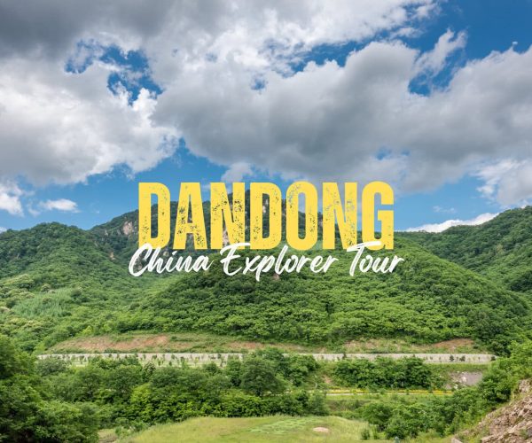Dandong,Liaoning,China tour Lush green hills under a blue sky with clouds; bold yellow 'DANDONG' and white cursive 'China Explorer Tour' text overlaying the landscape