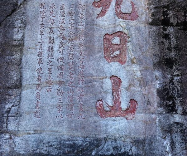 Jiuri Mountain Wind-praying Stone Inscription,Quanzhou,Chinatravel Stone rock slab with Chinese inscription: large red characters on the right and a column of smaller characters on the left of the slab.