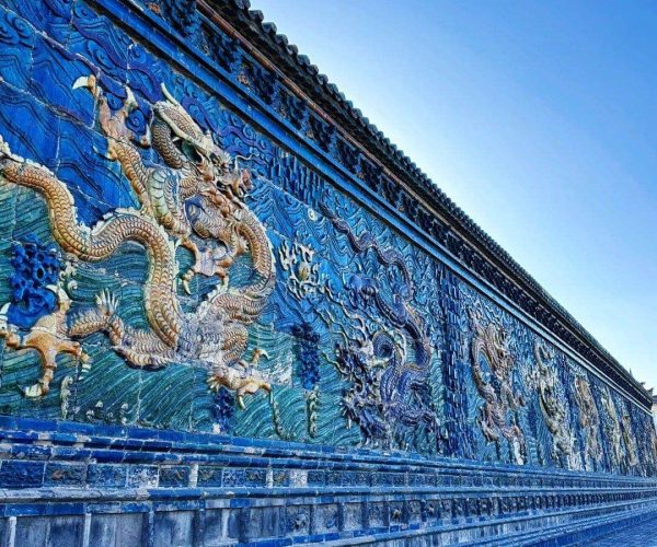 Nine-Dragon Screen’s Daoist Symbolism,Datong,Chinatravel Long blue wall covered in intricate dragon reliefs under a clear sky
