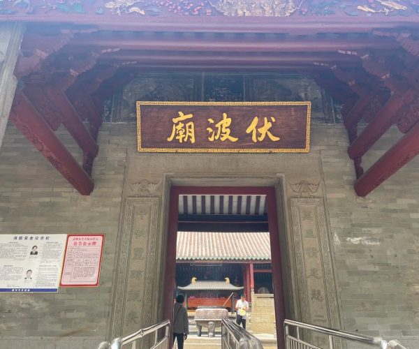 Fubo Hill Temple,Guilin,Chinatravel Entrance to a traditional Chinese temple with a gold Chinese-character plaque above the doorway, carved stone pillars, and red wooden beams.