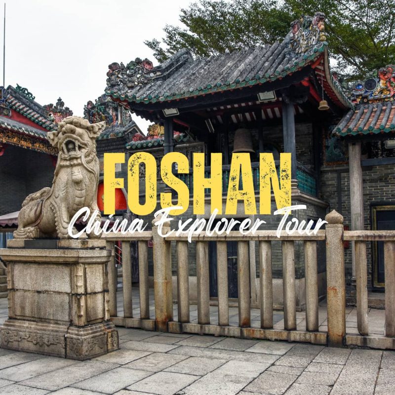 Foshan,Guangdong,Chinatravel Promotional banner reading 'FOSHAN China Explorer Tour' over a traditional Chinese temple entrance with a stone guardian lion statue in front.