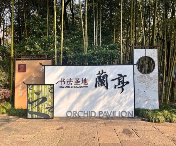Orchid Pavilion,Shaoxing,Chinatravel White sign saying 'Orchid Pavilion' with Chinese characters, set in a bamboo garden backdrop (Holy Land of Calligraphy).