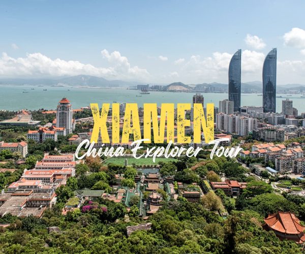 Xiamen,Fujina,Chinatravel Aerial view of Xiamen city with coast, skyscrapers and red-tiled roofs, overlaid with bold yellow ‘XIAMEN’ and white ‘China Explorer Tour’ text.”