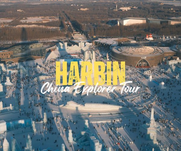 Harbin,Heilongjiang,Chinatravel Aerial view of Harbin Ice and Snow World with huge yellow 'HARBIN' title and white 'China Explorer Tour' text over a frozen plaza filled with people.