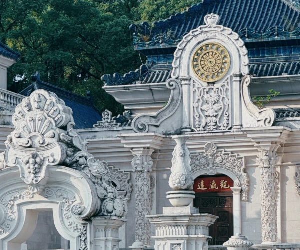 New Yuanming Palace,Zhuhai,Chinatravel Ornate white Chinese temple façade with intricate carvings and a blue tiled roof amid green trees?