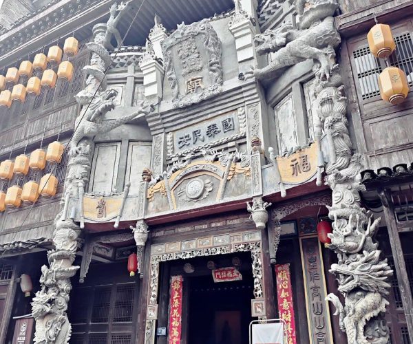 Guilin Ancient Town ,Guilin,Chinatravel Ornate Chinese temple facade with dragon sculptures surrounding the entrance and hanging lanterns on both sides of the doorway
