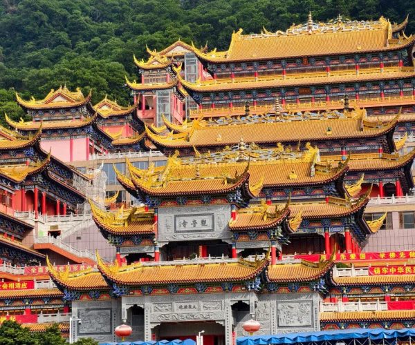 Dalingshan,Dongguan,Chinatravel Colorful multi-tier Chinese temple complex on a hillside, with yellow-tiled roofs and red pillars, set against green trees and a blue sky
