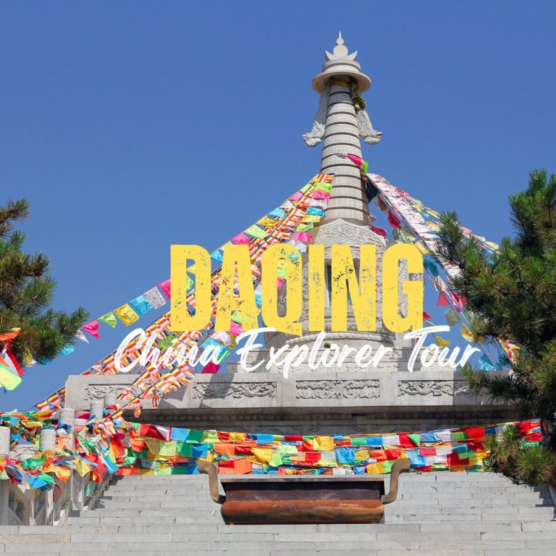 Daqing,Heilongjiang,Chinatravel Promotional travel image of a Buddhist stupa with multicolored prayer flags against a blue sky, bordered by stairs and trees.