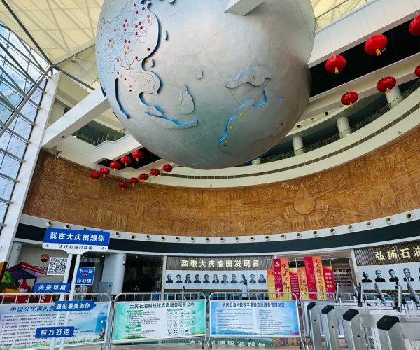 Daqing Oilfield History Museum,Daqing,Chinatravel Large spherical globe sculpture suspended in a modern museum atrium, with red lanterns and circular display boards along the wall.