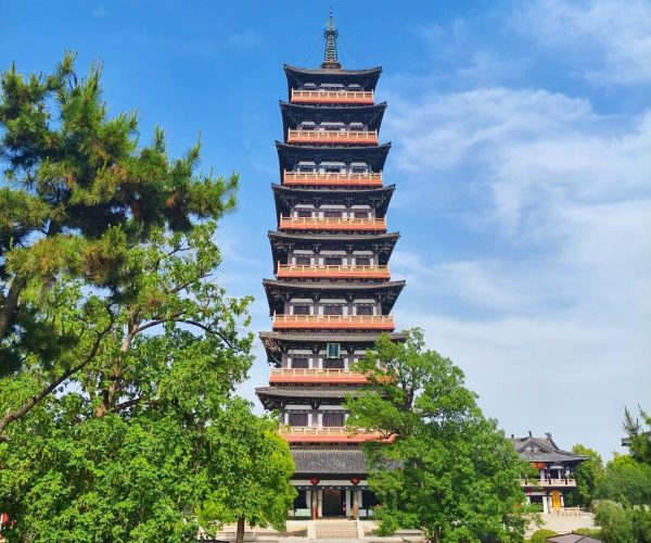 Daming Temple,Yangzhou,China tour Seven-story Chinese pagoda in a temple garden, surrounded by trees on a sunny day against a blue sky.
