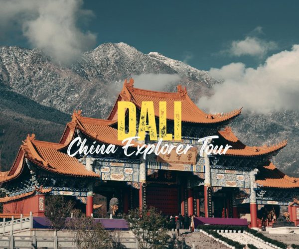 Dali,Yunan,Chinatravel Traditional Chinese temple with orange tiled roofs set against snow-capped mountains, overlaid with bold 'DALI' and cursive 'China Explorer Tour' text.