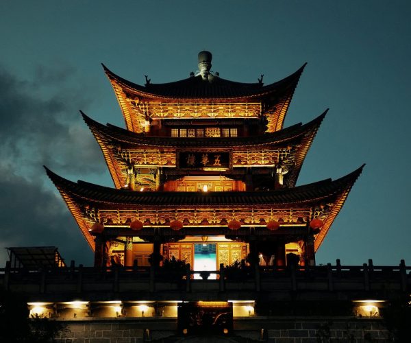 Dali Ancient City,Dali,Chinatravel Three-tier illuminated Chinese pagoda at night with ornate wooden carvings and red lanterns
