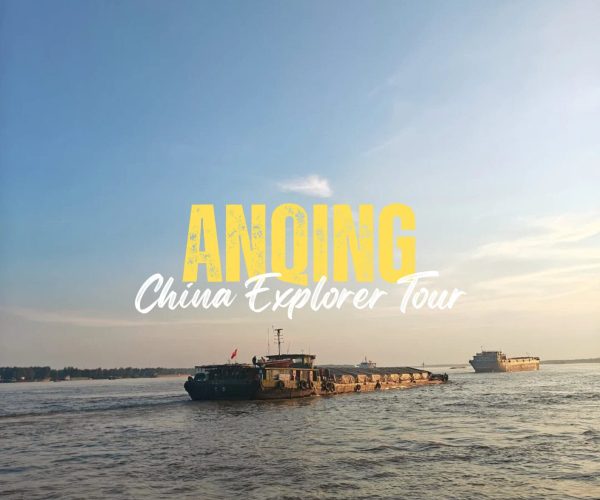 Anqing,Anhui,China tour Promotional banner for 'ANONG China Explorer Tour' on a calm river with large yellow text and boats in the background.