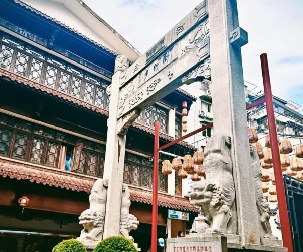 Anqing Ancient City,Anqing,China tour Stone stone archway with dragon pillars in a traditional Chinese temple courtyard, red lanterns, and ornate wooden buildings.