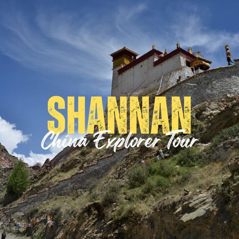 Shannan,Tibet,China tour Promotional image: hillside fortress with blue sky, large yellow 'SHANNAN' text and white 'China Explorer Tour' subtitle overlaying the scene.