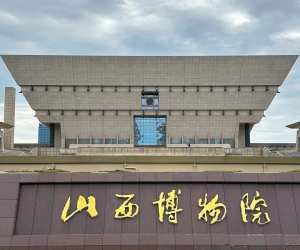 Shanxi Museum,Taiyuan,Chinatravel Front view of the Shanxi Museum exterior with a dark wall displaying large gold Chinese characters 山西博物院 against a cloudy sky.
