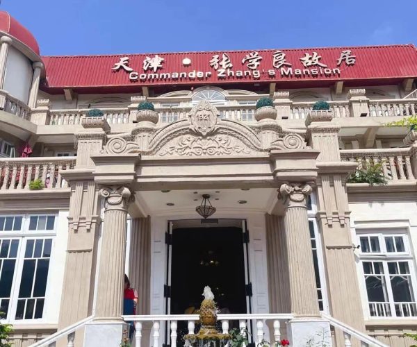 Marshal Zhang’s Mansion,Shenyang,China tour Commander Zhang's Mansion entrance with ornate stone arch, balcony, and central fountain in front.
