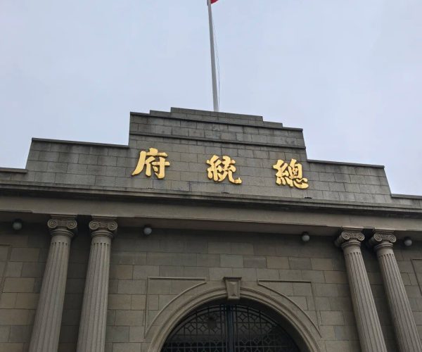 Presidential Palace,Nanjing,China tour Gray stone government building with gold Chinese characters above the entrance and a Chinese flag atop the flagpole.