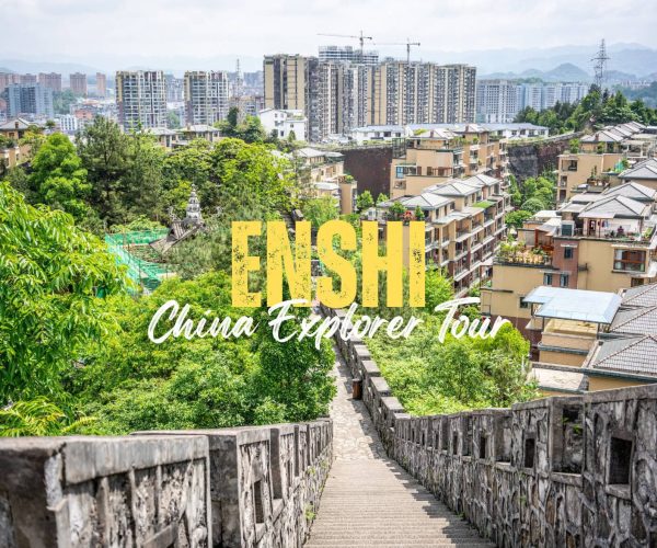Enshi,Hubei,Chinatravel Promotional banner for ENSH China Explorer Tour with a stone staircase leading to a cityscape of buildings and greenery.