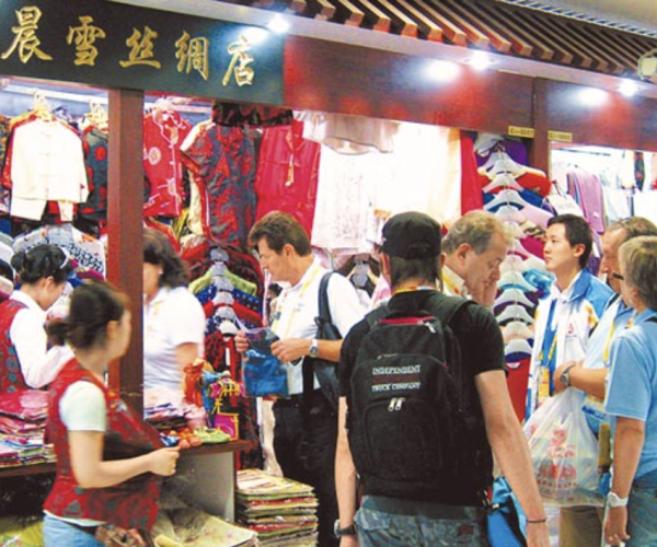 beijing, chinatravel, Busy indoor clothing market stall with colorful traditional garments and shoppers browsing.