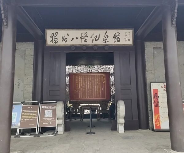 Yangzhou Eight Eccentrics Memorial Hall,Yangzhou,China tour Entrance to a traditional Chinese hall with dark wooden columns and a hanging calligraphy sign; inside, a large red plaque with gold text.