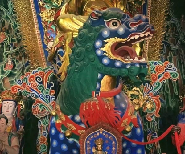 Ancient Manjushri Temple Mount Wutai,Xinzhou,Chinatravel Elaborate temple altar featuring a golden Buddha behind a turquoise-green dragon statue and intricate gold decorations.