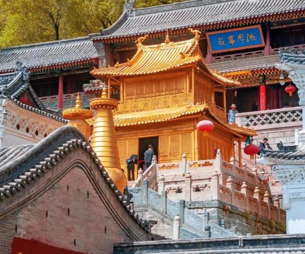 Xiantong Temple,Xinzhou,Chinatravel Golden pagoda-like temple pavilion atop stone stairs, framed by bright autumn yellow trees.