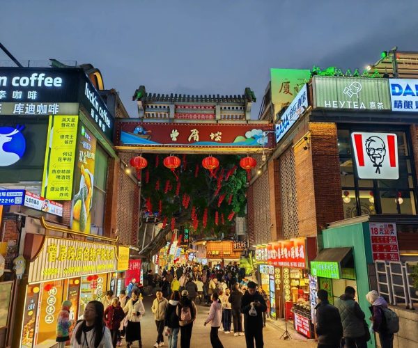 Zengcuoan Coastal Art Village,Xiamen,Chinatravel Crowded night market under a traditional Chinese gate, with red lanterns and bright storefronts.