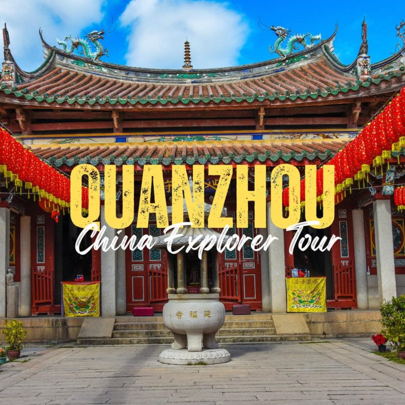 Quanzhou,Fujian,Chinatravel Promotional banner over a Chinese temple courtyard, reading 'GUANZHOU China Explorer Tour' with red lanterns lining the entrance.