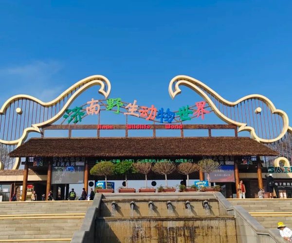 Jinan Wildlife World,Jinan,China tour Entrance to Jinan Wildlife World with a colorful sign and decorative arches, and a tiered fountain in front.