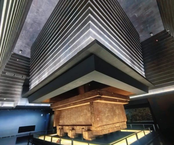 Hunan Provincial Museum,Changsha,Chinatravel A large, layered, pyramid-like structure suspended above a wooden block base in a museum exhibit.