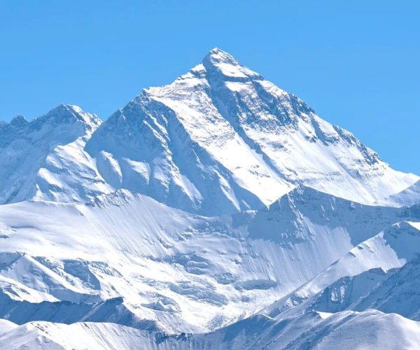 Mount Everest,Shigatse,China tour Snowy mountain range beneath a clear blue sky with jagged, snow-covered peaks.