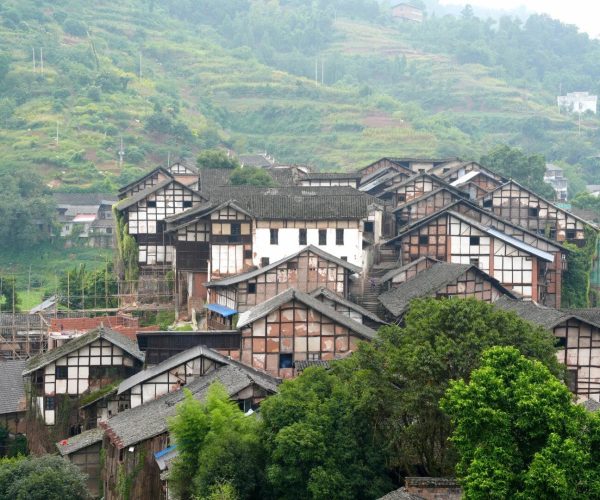 Hejiang Ancient Town,Luzhou,Chinatravel Traditional timber-framed houses cluster on a hillside village with tiled roofs and greenery.