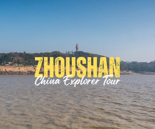 Zhoushan,Zhejiang,Chinatravel Bold yellow 'ZHOU SHAN' with white cursive 'China Explorer Tour' over a coastal landscape and statue on a hill—promotional banner.