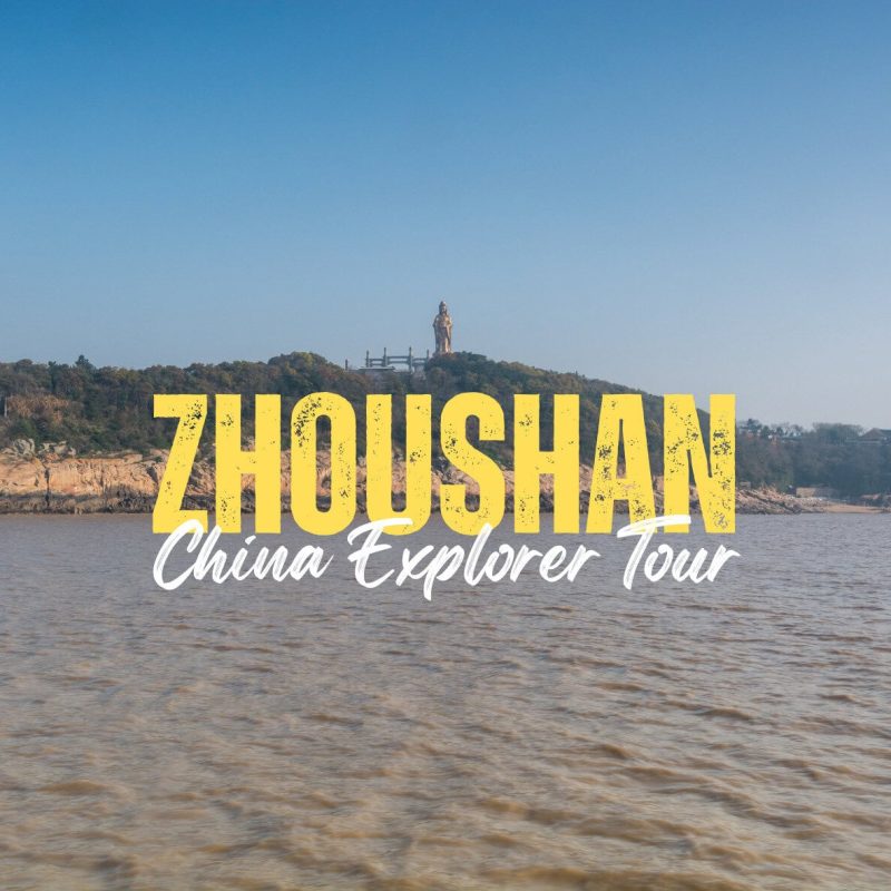 Zhoushan,Zhejiang,Chinatravel Bold yellow 'ZHOU SHAN' with white cursive 'China Explorer Tour' over a coastal landscape and statue on a hill—promotional banner.