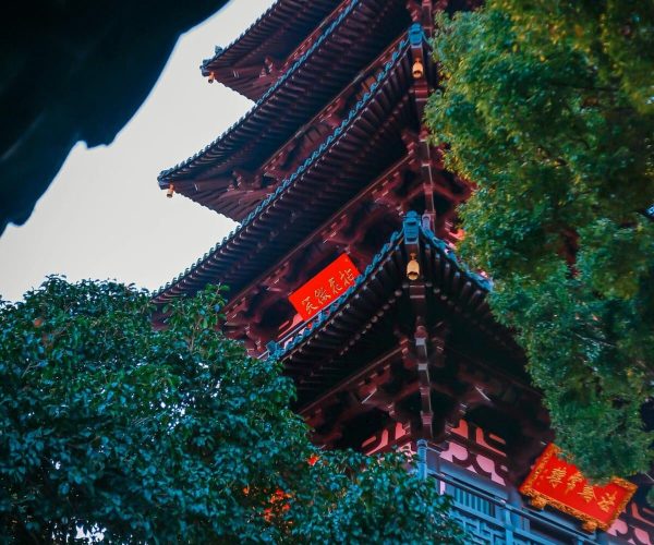 Suzhou Old Town,Suzhou,Chinatravel Red multi-tiered traditional pagoda peeking through lush green trees.