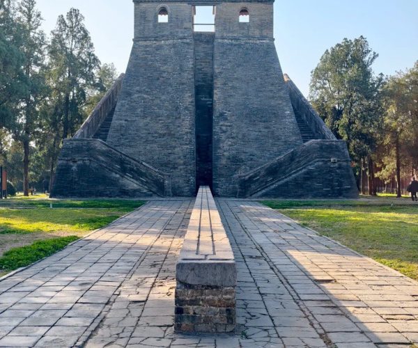 Observatory,Shaolin & Songshan Area,Chinatrip Front view of a historic stone monument with twin staircases and a central opening, surrounded by trees in a park setting.