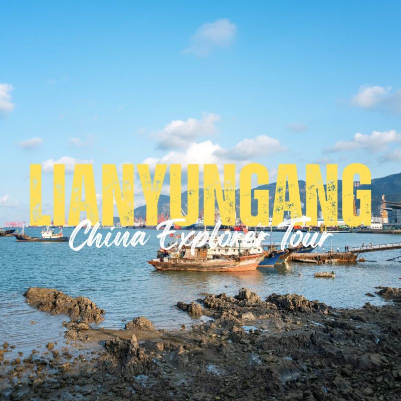 Lianyungang,Jiangsu,China tour Harbor scene with boats on calm water and rocky shore, overlayed by bold yellow text 'LIANYONGANG' and white cursive 'China Explorer Tour'