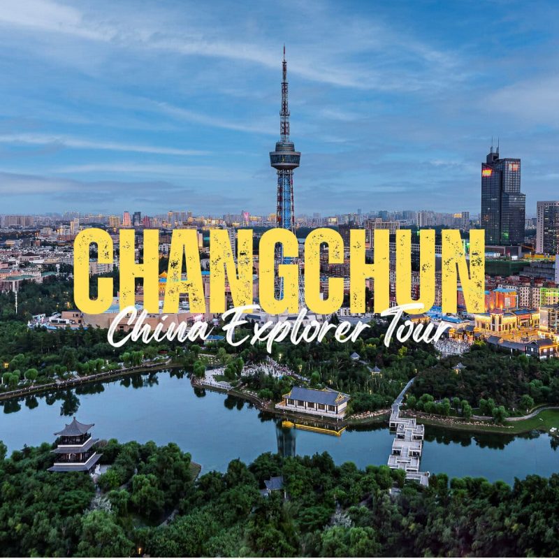 Changchun,Jilin,China tour Aerial view of Changchun with a river park in the foreground and a city skyline; large yellow text reading CHANGCHUN with white script 'China Explorer Tour' overlaying the scene.